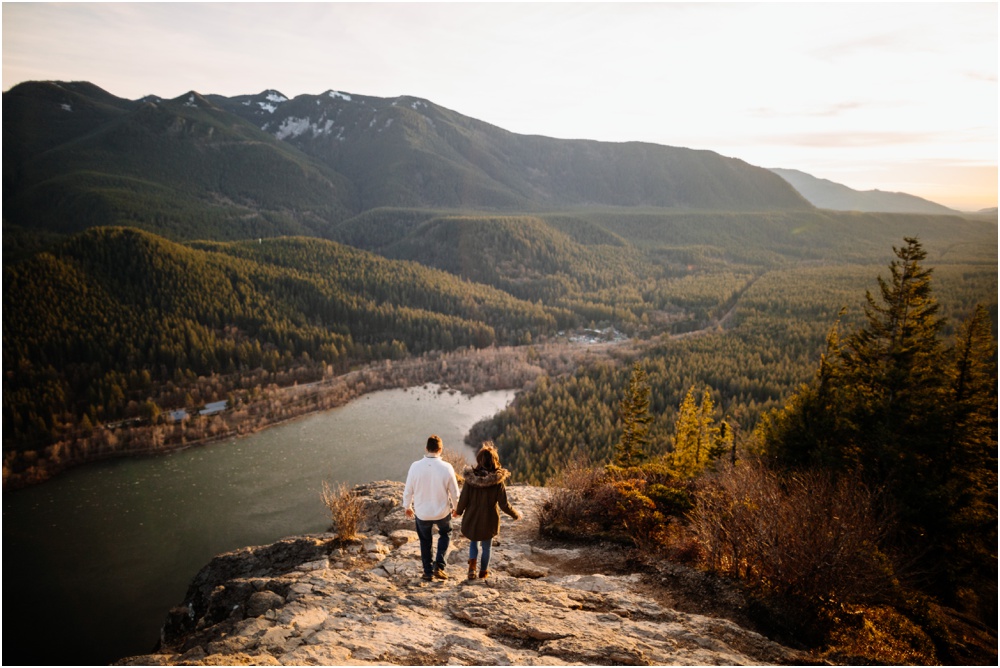 Couple walks down hill of rocks Sunset Rattlesnake Ledge Engagement