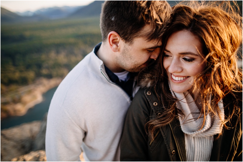 Man kisses woman's cheek hiking engagement