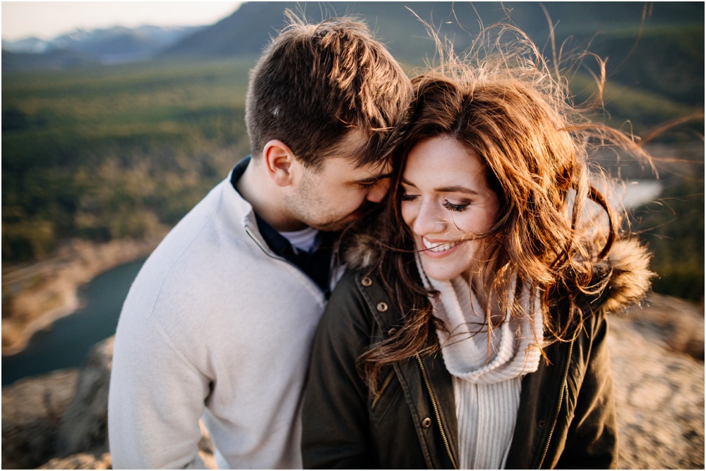 Man snuggles with woman Sunset hiking enegagement