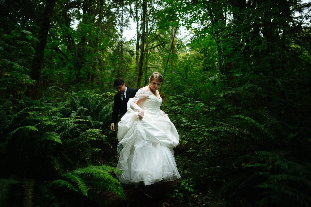 bride and groom walk through the woods during their washington state elopement at salish lodge