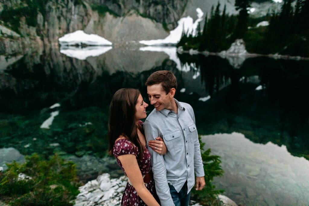 couple kisses by mountain lake