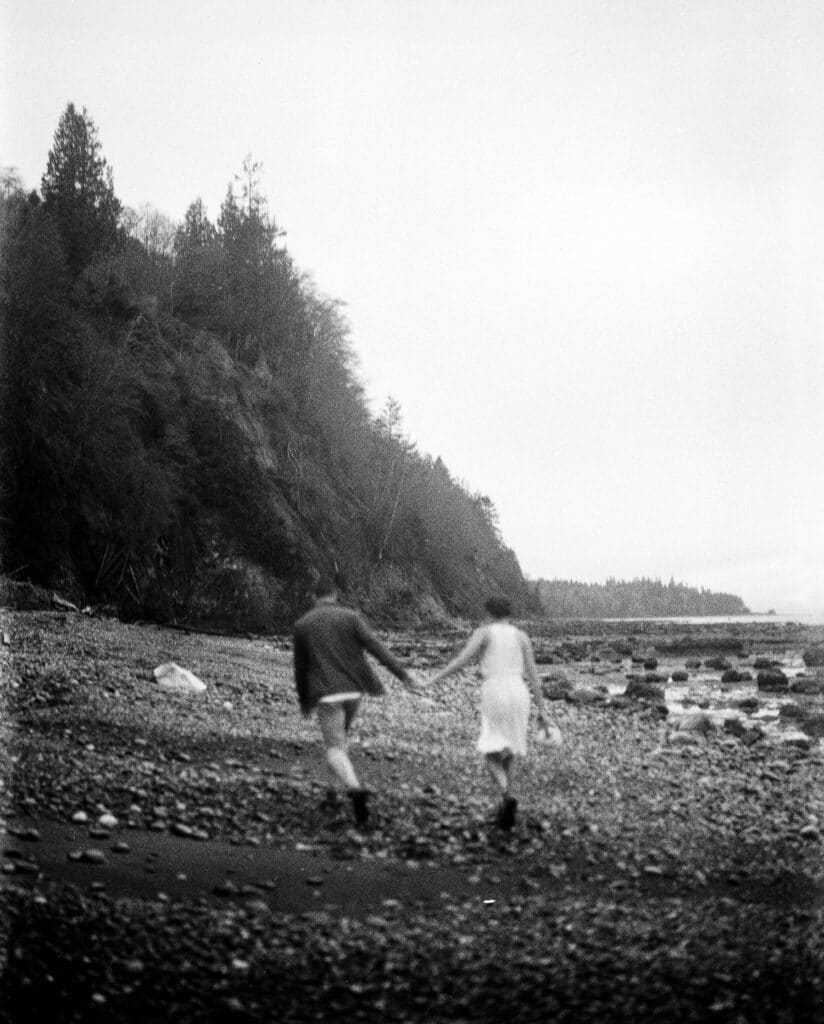 couple runs on the beach on film during olympic national park elopement