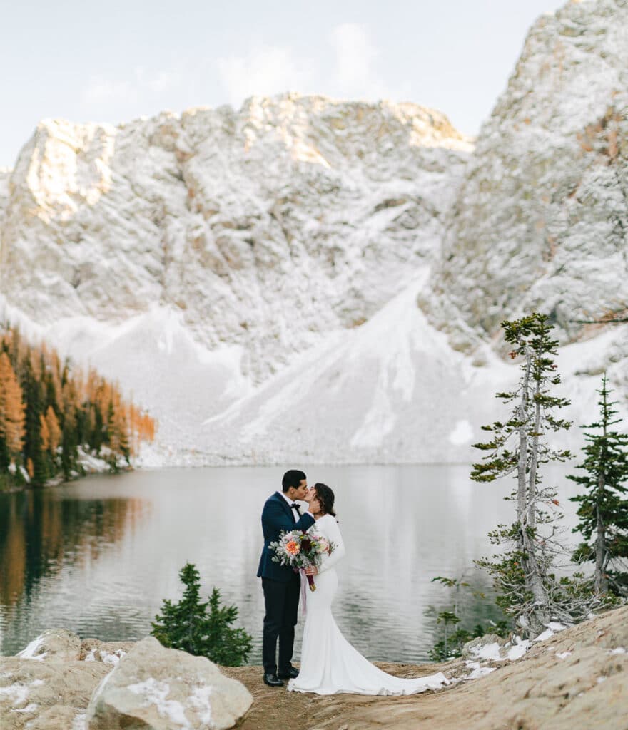 couple kisses in front of snowy wall at north cascades elopement