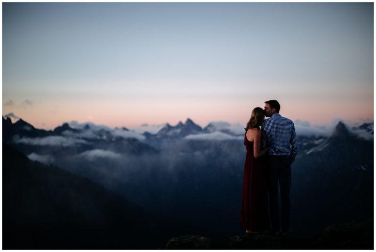 couple stands with reflection PNW backpacking engagement