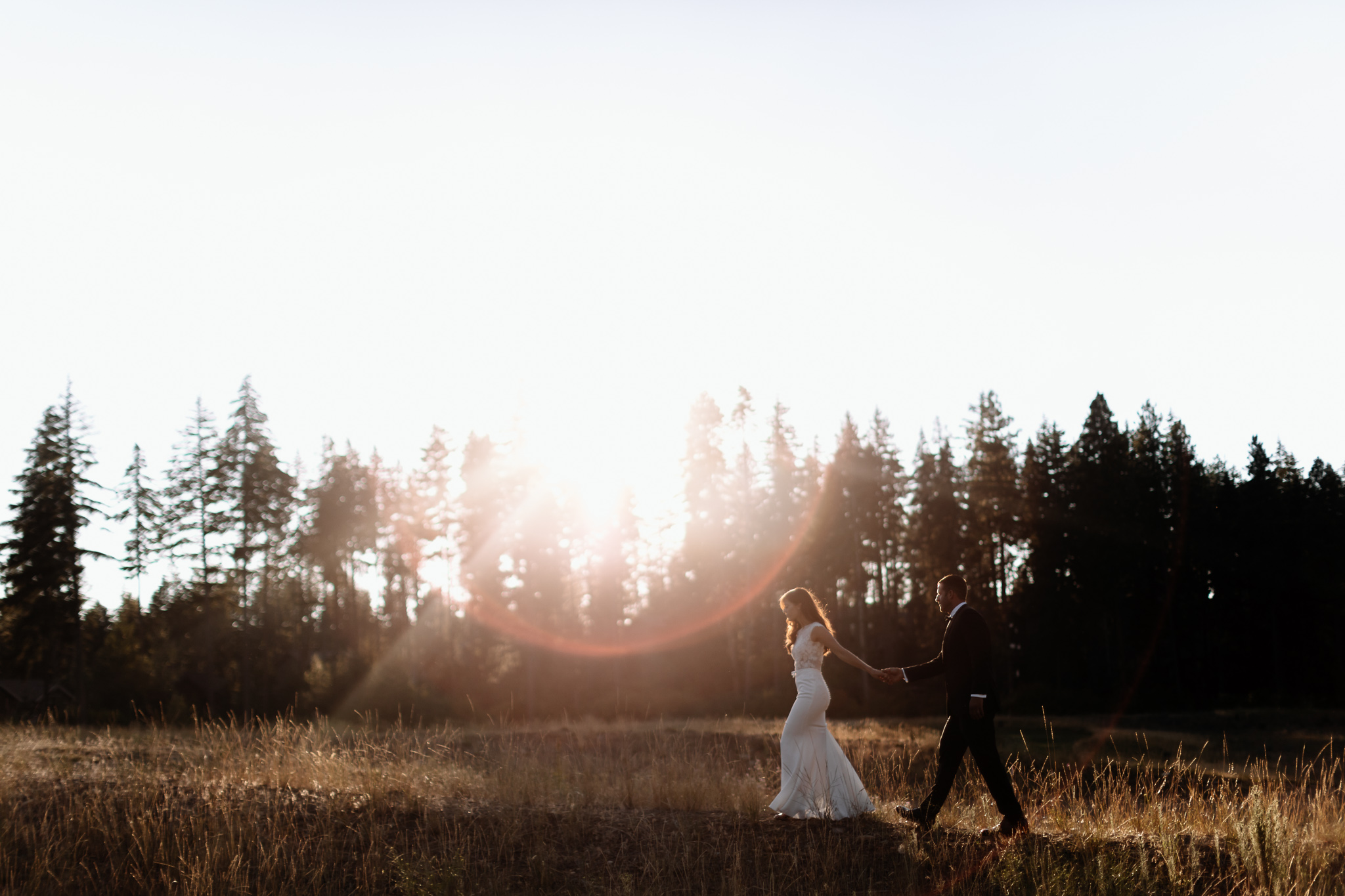 Bride and groom walk in the sunset swiftwater cellars wedding