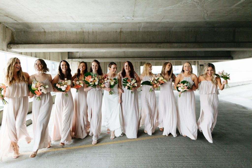 bridesmaids laugh and walk in modern space