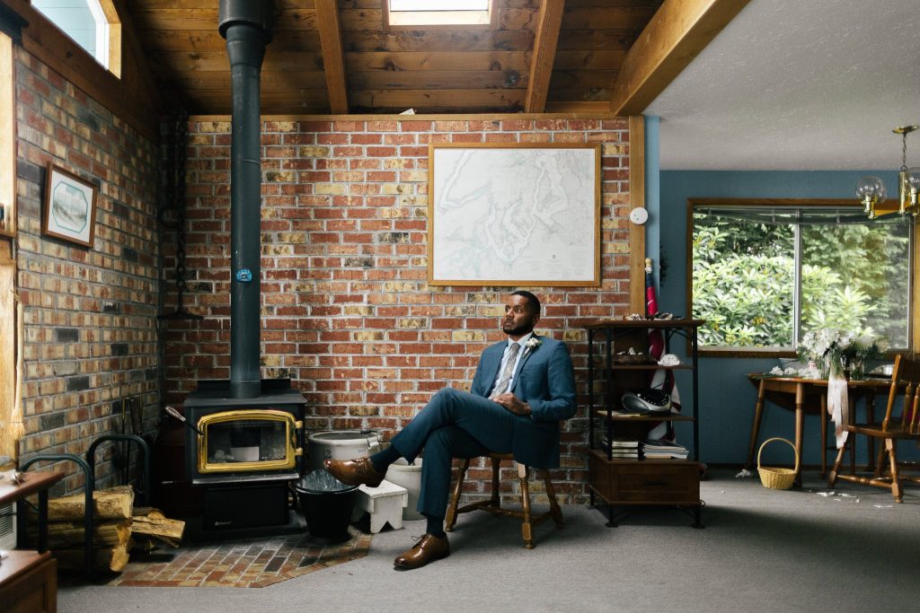 Groom poses in family cabin during washington state elopement near seattle