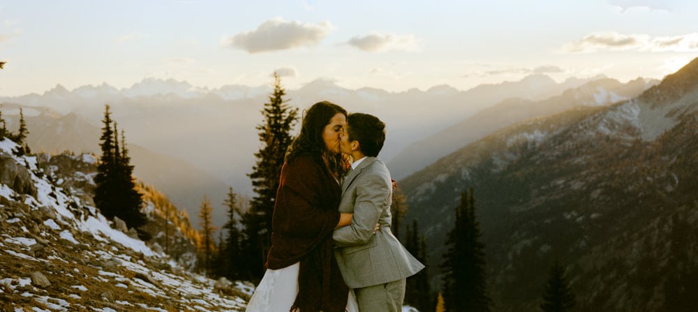 Panorama photo of brides kissing during larch elopement