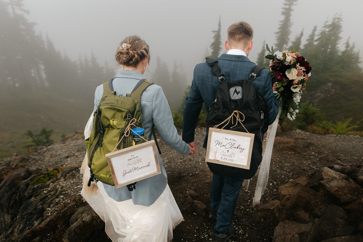 bride and groom hike with just married sign in north cascades du